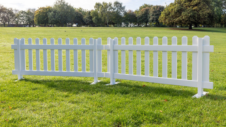 Two white portable picket fence panels with heavy duty steel mounts, 6ft x 2ft 8in vinyl fencing by Simple Fencing.
