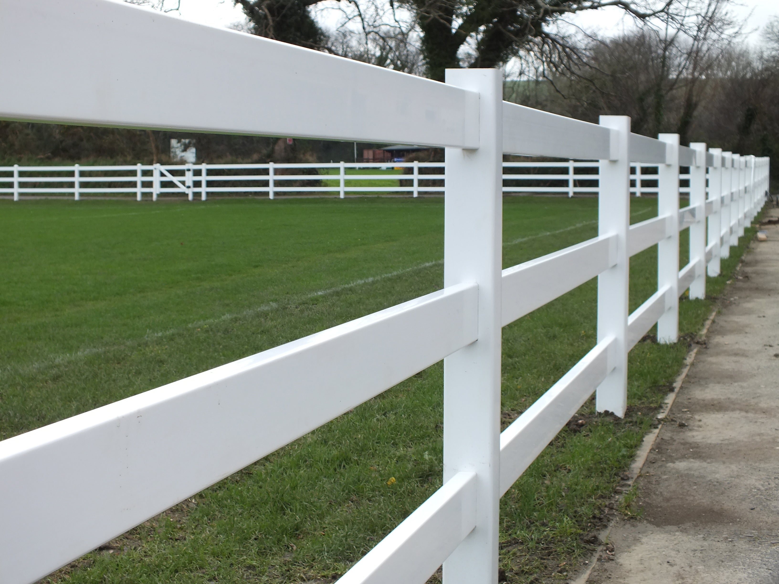 A Simple Fencing three-rail white vinyl fence providing a strong and low-maintenance enclosure for a field or paddock.