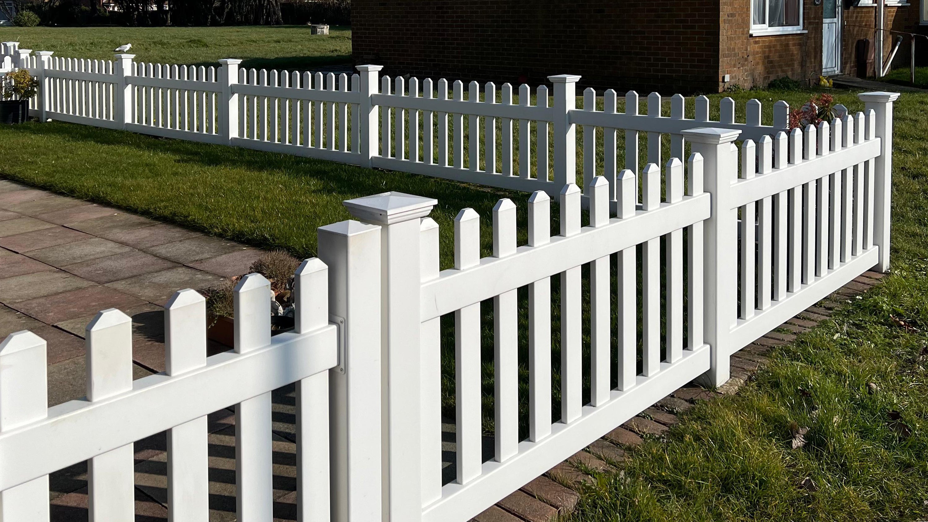 Simple Fencing picket fence installation around a UK home garden, showing durable PVC posts and panels.