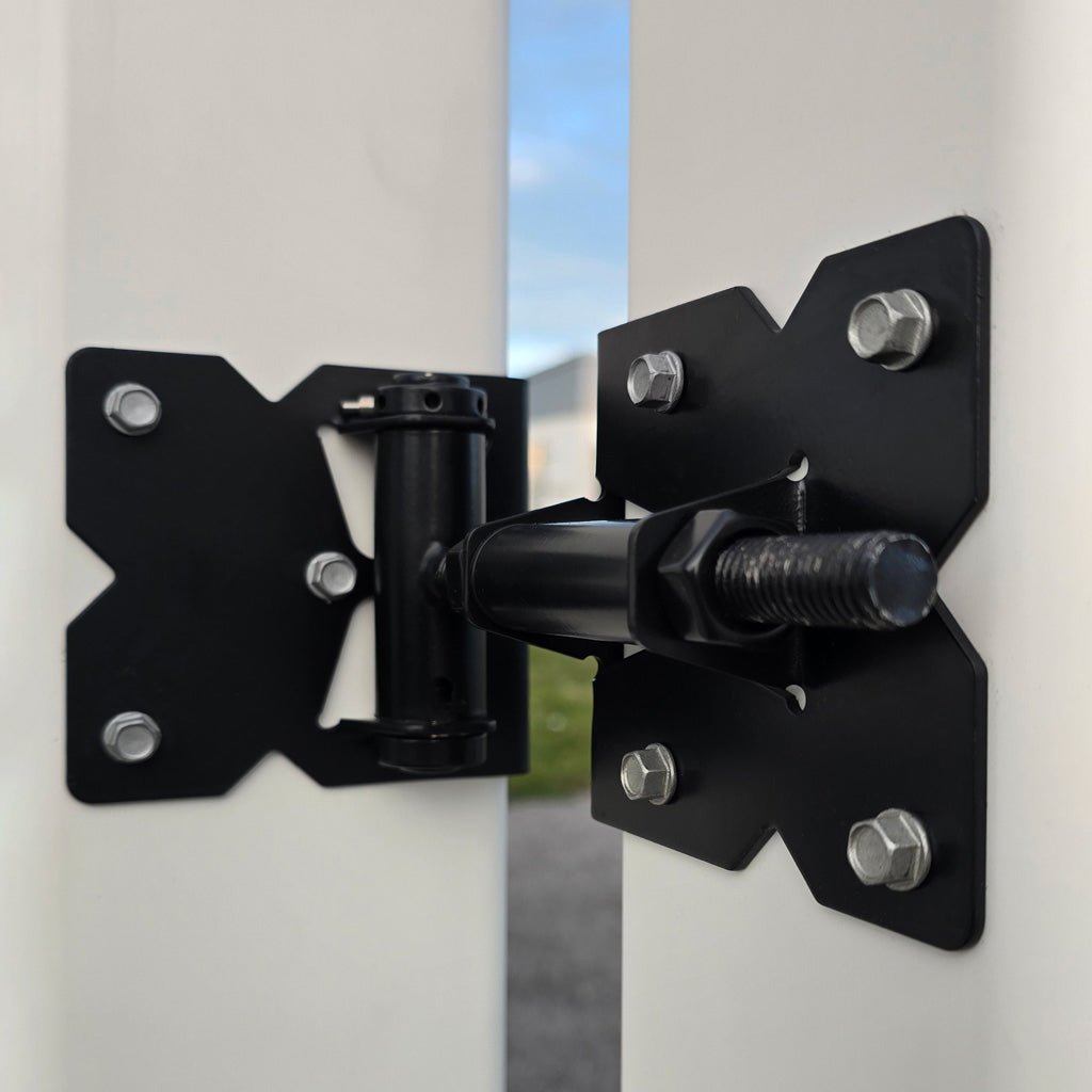 Black metal hinge installed on square white vinyl gate posts.