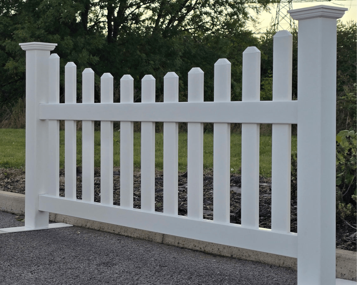 White picket fence with greenery in the background by Simple Fencing