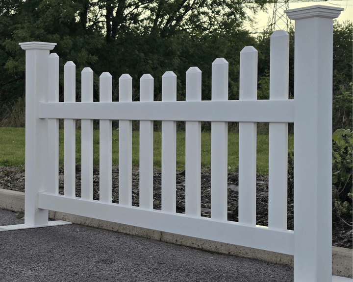 White picket fence with greenery in the background by Simple Fencing