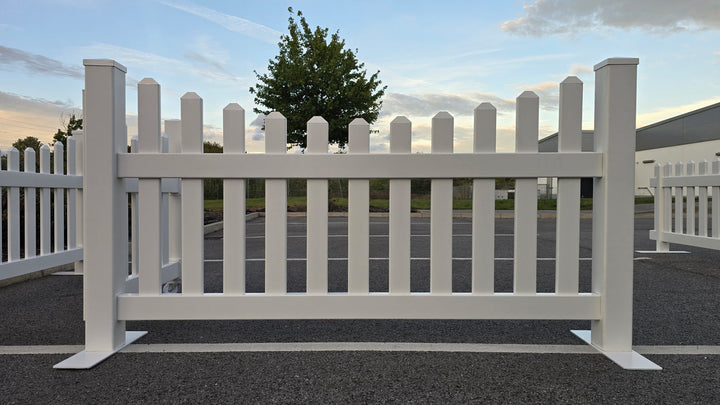 The Simple Fencing portable classic scalloped picket fence panel is a zero-maintenance vinyl fencing solution featuring durable steel feet, ideal for events and commercial venues.